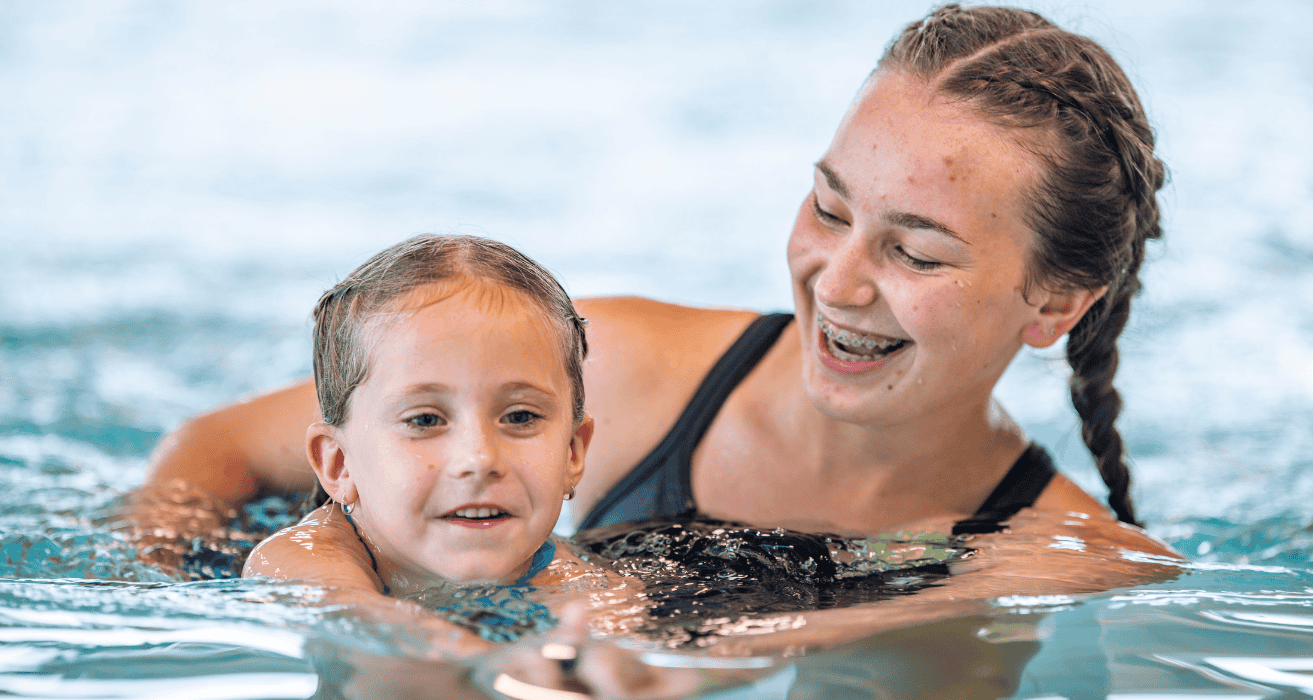 Stock (1500 x 800 px) (6) female swim instructor swimming with camper